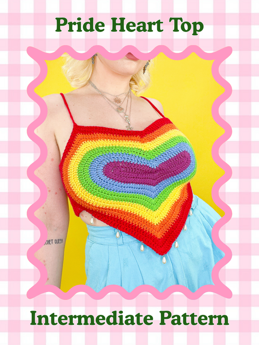 Crochet pattern cover of a woman wearing a heart shaped top with a rainbow design and blue trousers to match with the words 'rainbow heart top' and skill level 'intermediate' on the cover.
