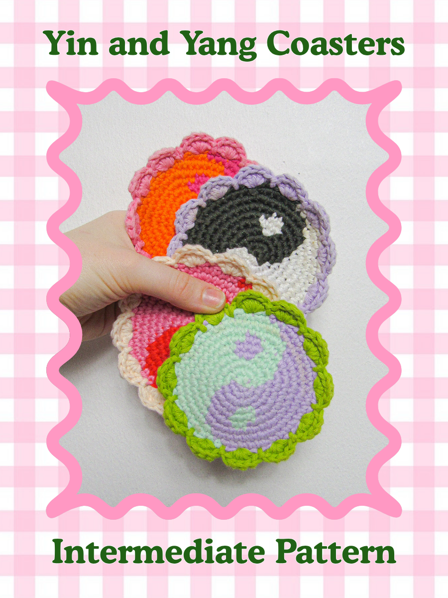 Pattern cover of a hand holding four crochet coasters with a yin yang design and frilled edges in front of a wall with decor around and the words 'yin and yang coasters' and skill level 'intermediate' on the front. 